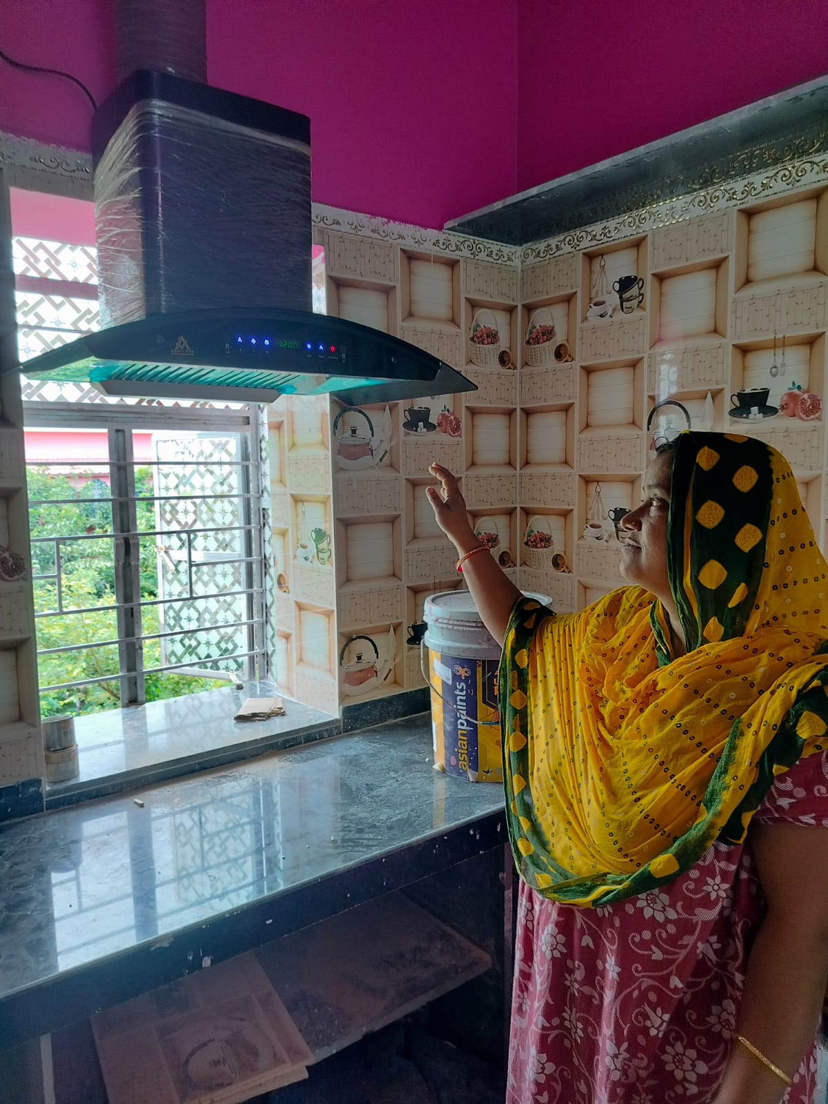 Customer inspecting her newly installed NexElectra kitchen chimney in West Bengal